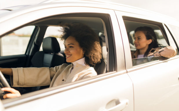 Photo of a woman being driven around town in a white vehicle.